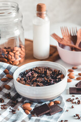 Healthy breakfast in a bowl with homemade baked granola, frozen berries