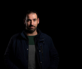 Attractive bearded man putting on a blue jacket posing isolated