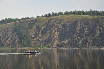 People ride an inflatable boat on the Tom River in Western Siberia