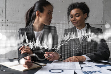 Two businesswomen work together in modern office on new project. Double exposure. Concept of success. Forex stock market graph.