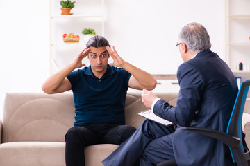 Young man visiting old male psychologist