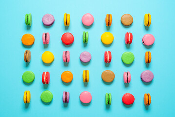 Macarons aligned on a blue background. Multi-colored macarons flat lay.
