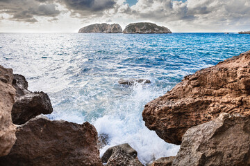 Waves crashing against the rocks in coastal landscape. Malgrats Islands in Mallorca. Mediterranean Sea in storm