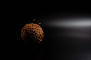 whole coconut on black background