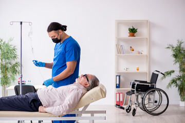 Old patient visiting young male doctor for intravenous therapy