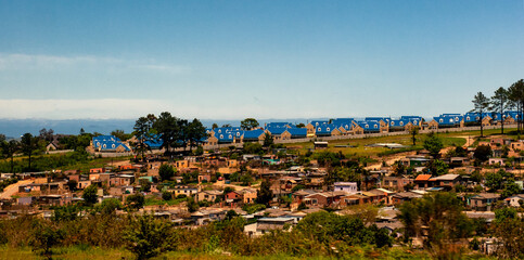 Obraz premium Township in the foreground and settlement with blue roofs in the background near Port Elisabeth, South Africa
