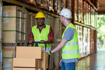 Distribution warehouse manager in discussion with colleagues in a large distribution warehouse.