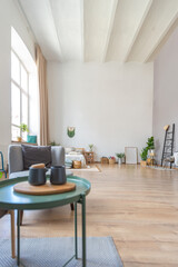 interior of stylish loft. spacious apartment with large windows, parquet on the floor and light walls. closeup view of shelving with different small things for decoration