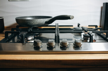 A metal silver pan on the gas stove in the kitchen.
