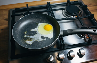 Fried egg on the pan. Preparing breakfast on the gas stove in the kitchen.