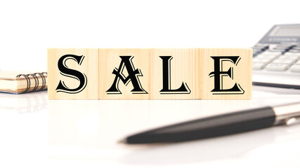 Sale word made with building blocks, business concept. near pen, Notepad, calculator