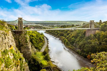A view looking up the Avon gorge towards Bristol with the Clifton Suspension bridge across the gorge on a bright Autumn day - obrazy, fototapety, plakaty