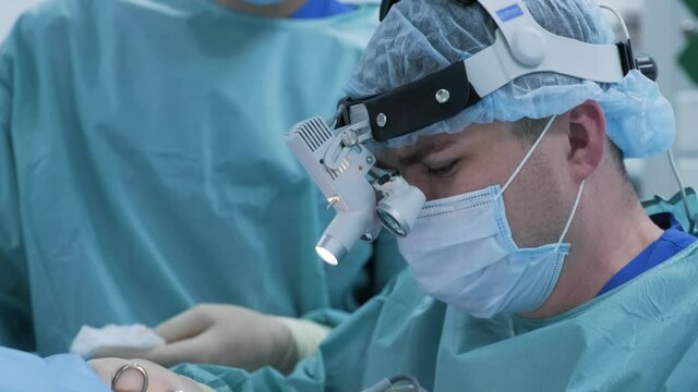Operation to remove tonsils. In modern clinic under deep anesthesia, using latest devices patient removes glands, cold plasma method, cuts swelling in throat, doctor works with new probe