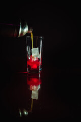 The mix of lemon syrup and tequilla poured into red grenadine