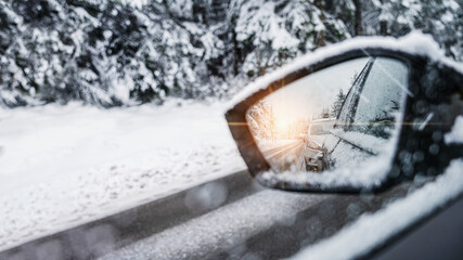 winter panorama on the road in the rearview mirror of a car
