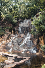 Fototapeta premium Beautiful small waterfall flows into the forest pond at the end of the hiking path of Faial da Terra, Sao Miguel, Azores.