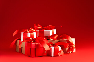 Boxes with gifts tied with ribbons stand on a red background, horizontal orientation, copy space