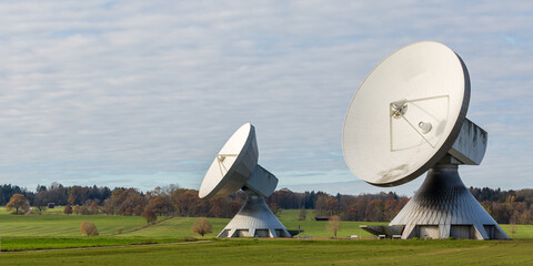 Panorama photo with two huge satellite dishes in upper bavarian landscape. Earth station for...