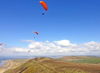 Paragliding above Rhossili Beach in Wales	