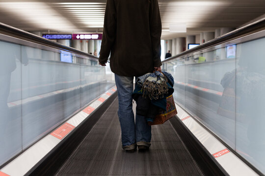 A woman walking through an airport during the coronavirus pandemic wearing a surgical mask