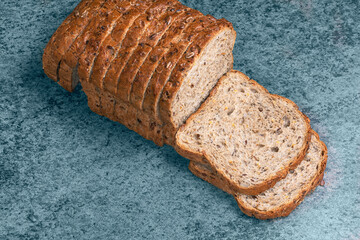 fresh rectangular wheat bread with various seeds and nuts on a wooden table