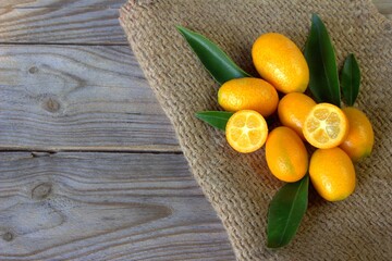 Fresh kumquats on a wooden board. Citrus background. 