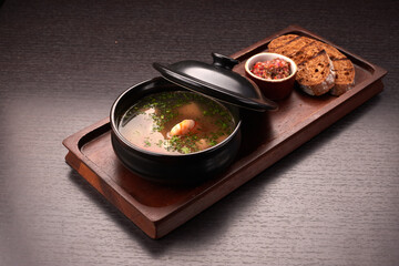 Soup with shrimps, sauce, bread, croutons, on a wooden board