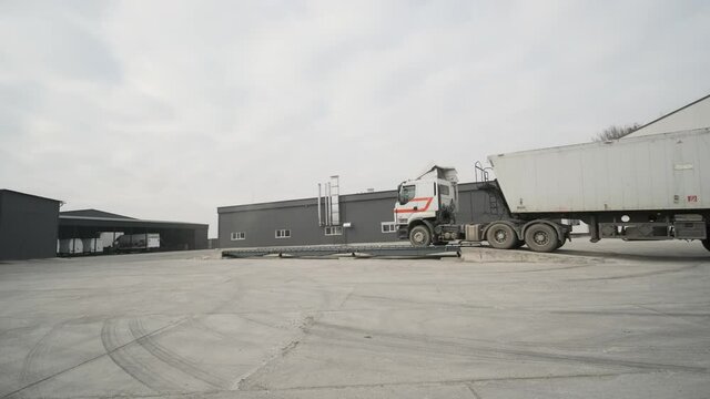 Truck with raw materials is weighed on the scales in the grain storage area. Truck scales