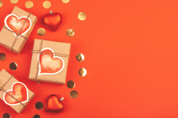 Composition with gift boxes and confetti on red. Background with copy space for Valentine's Day.
