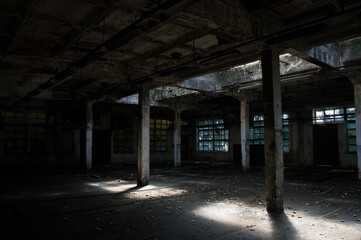 Fototapeta na wymiar Abandoned industrial hall - dirty, neglected room with broken windows