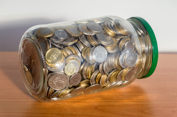 Polish coins money in jar on wooden table.