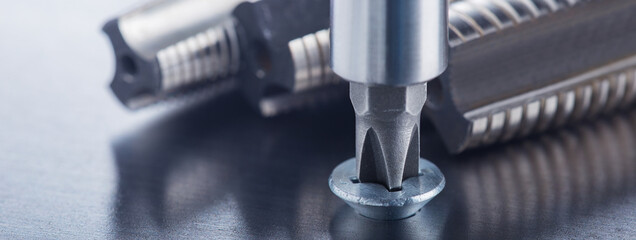 Screwdriver screw in metal steel plate bolt. Spanner, bolt, screw and nuts.