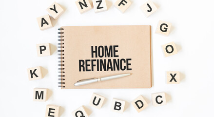 Text Home refinance on the craft colored notepad with block wood cubes on the white background