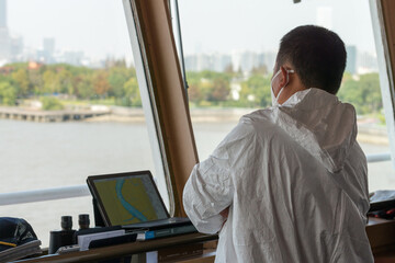Ship pilot on the vessel bridge keeping watch onboard during pilotage. © Denys Yelmanov 