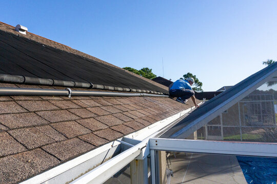 60 Year Old Man Inspects Gutter On Roof In Florida