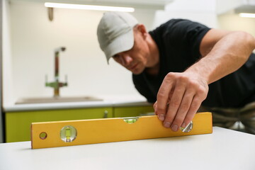 using of construction level in refurbishment. the builder checks the level of furniture installation