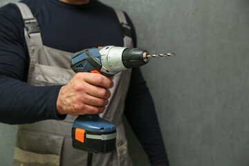 person's hands holds wireless drill close up