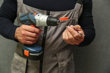 person's hands holds wireless drill close up