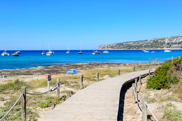 Obraz premium Pasarela de madera natural en playa sobre la arena camino hacia el mar
