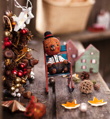 new year and christmas background. wooden toy bear in rocker and winter wreath behind...