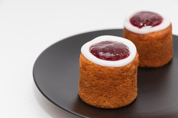Traditional Finnish pastry Runeberg torte (Runebergin torttu) on a black plate, close-up