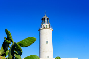Faro marítimo en acantilado con cielo y mar azul