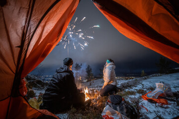 New Year camping trip - 31 Dec 2020 : Man and girl sitting infront of campfire and looking up in...