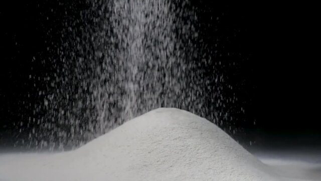 Sifting flour on a black background for homemade bake. Slow motion. Full HD video