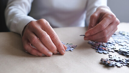 Obraz premium middle-aged woman doing puzzle for dementia.