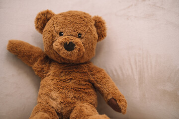 teddy brown bear sits and waves its paw, toy
