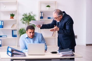 Old boss and his young assistant in the office