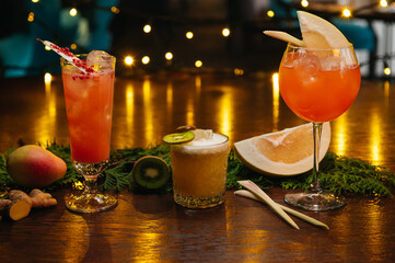 Three exotic cocktails on the table. Sour cocktail, pear cocktail and aperol spritz