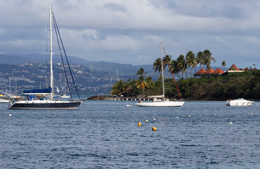 Fototapeta na wymiar The catamaran and sailboats anchored in waters of caribbean beach.