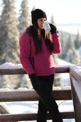 Girl on winter snowy fir tree background on ski resort